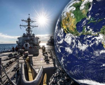 A US Navy destroyer sailing at sea with the Earth in the background
