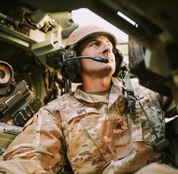 Uniformed military personnel equipped with devices operating inside a military vehicle