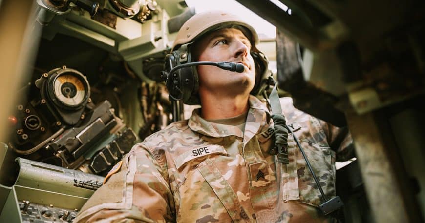 Uniformed military personnel equipped with devices operating inside a military vehicle