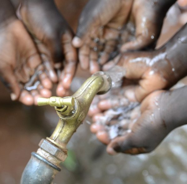 Hands of African Children Cupped under Tap Drinking Water Malnutrition