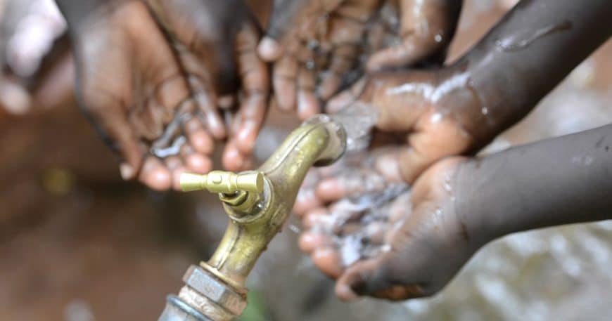 Hands of African Children Cupped under Tap Drinking Water Malnutrition
