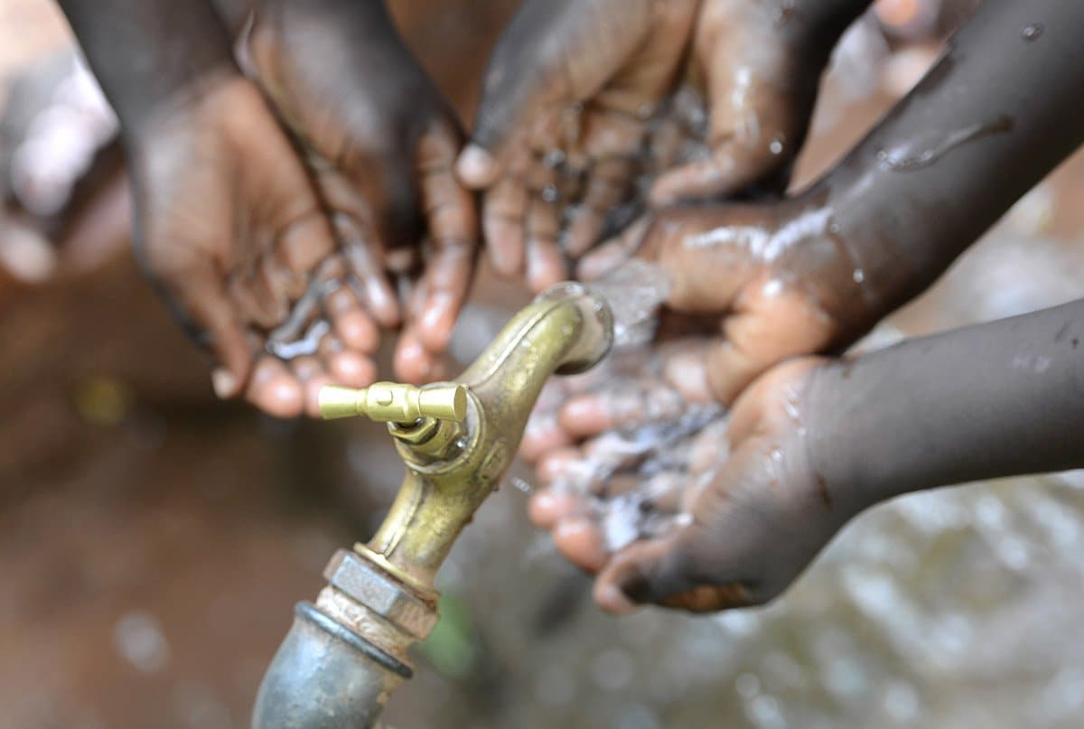 Hands of African Children Cupped under Tap Drinking Water Malnutrition