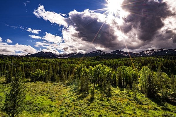 Sun shining on mountains and trees.